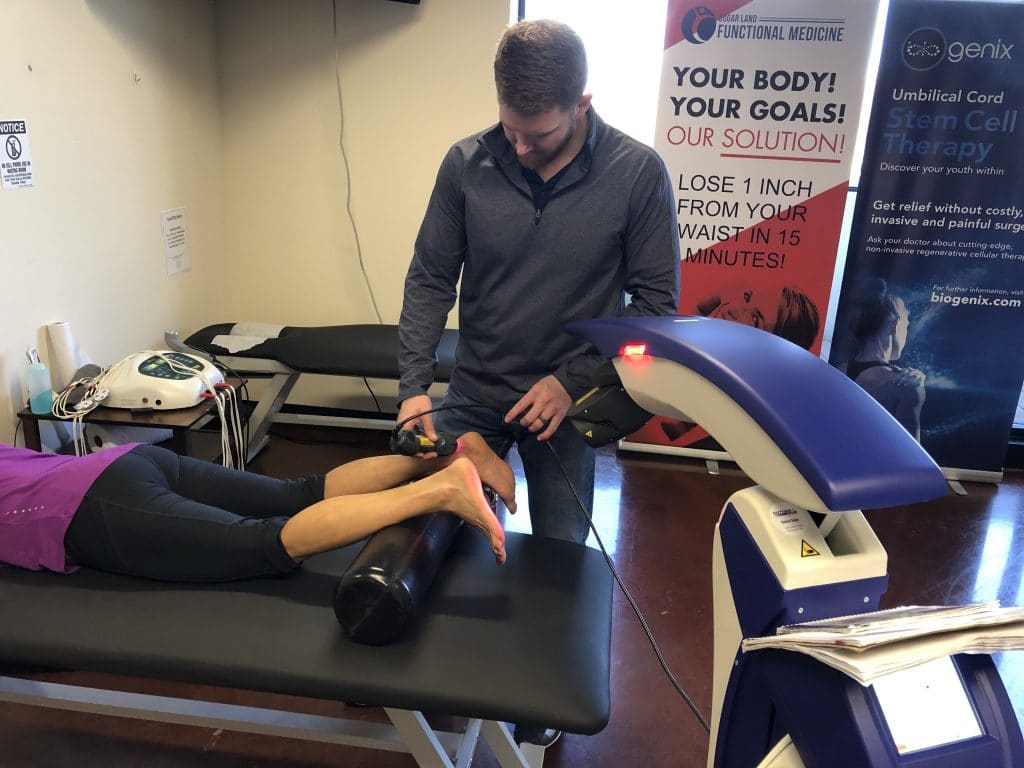 doctor performing MLS laser therapy on patients foot