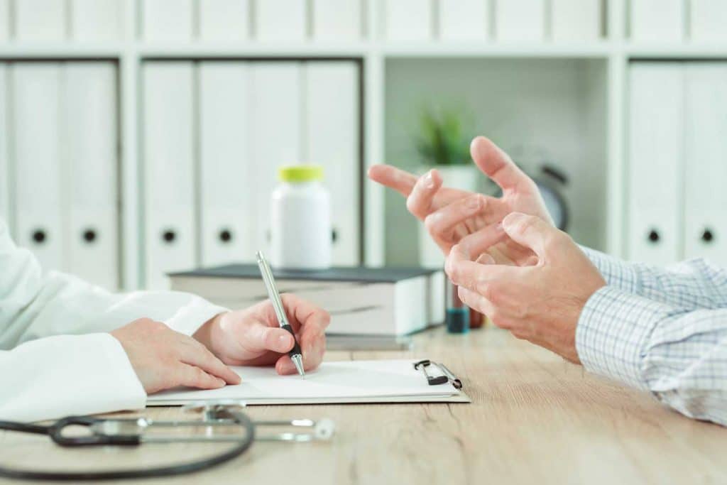 Doctor and patient during consultation in medical office, insured and covered chiropractic care