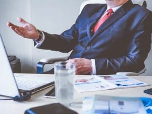 Man in suit speaking to someone. Your consultation at Hogan Spine & Rehab.