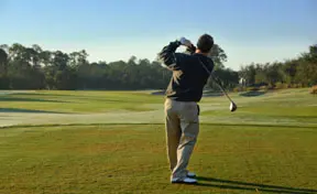 Golfer swinging the club. Body pain treatment available at Hogan Spine & Rehab