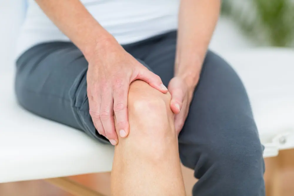 Patient holding his knee due to some joint or knee pain.