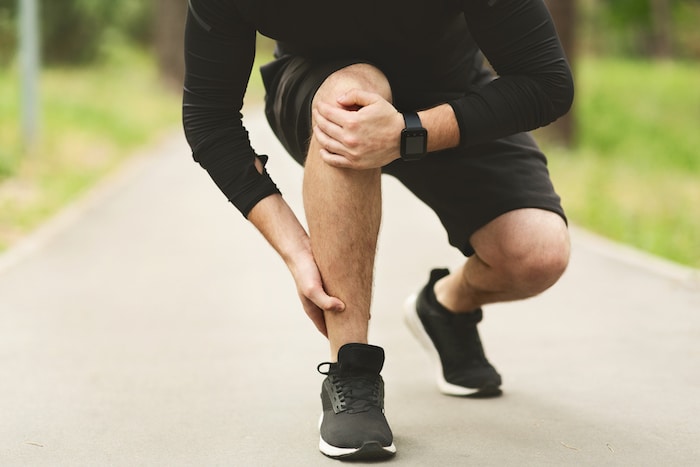 Male runner is suffering from ankle pain on jogging