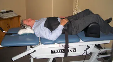 Man lying on traction bed to receive decompression therapy at Hogan Spine & Rehab