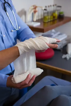 Patient having his hand wrapped with a bandage. Hogan Spine & Rehab wrist pain treatment.