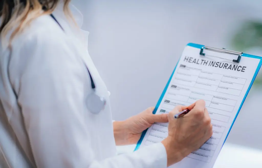 Doctor filling up a patient's health insurance details