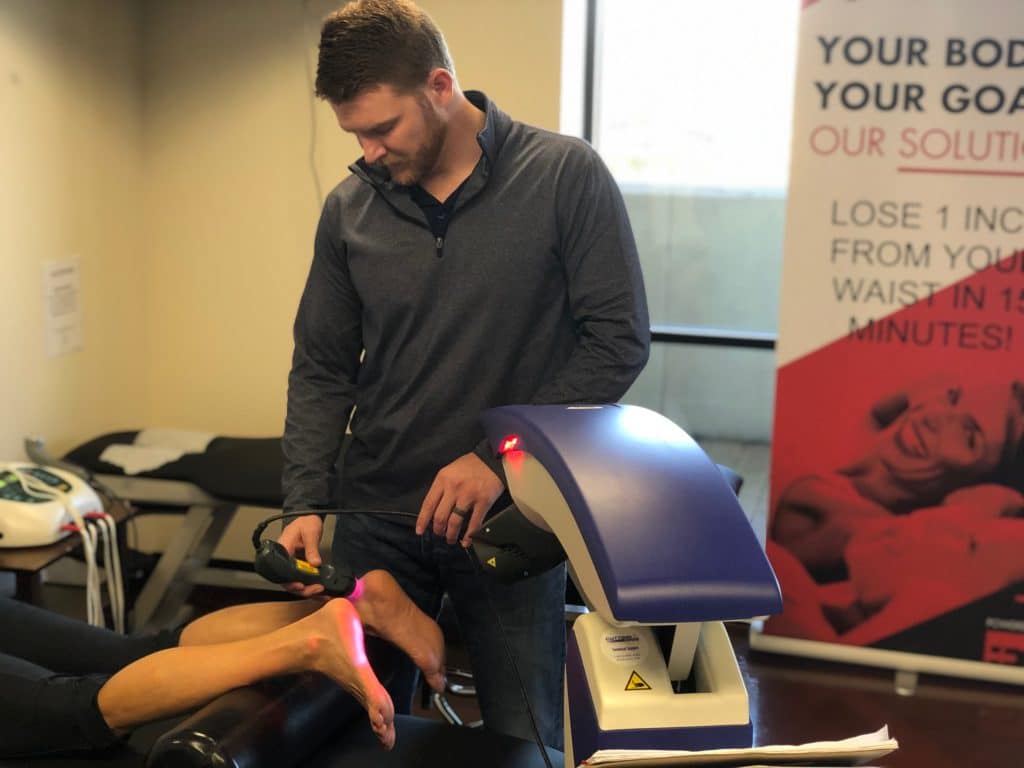 Hogan Chiropractic's doctor doing laser treatment on patient's neuropathic foot.