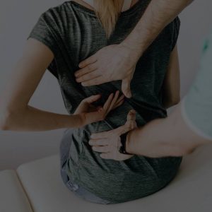 Chiropractic doctor examining a patient's back during a chiropractic care exam.