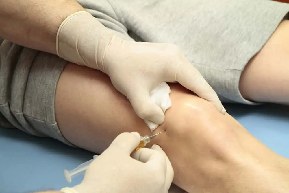 Patient receiving stem cell injection on his knee.