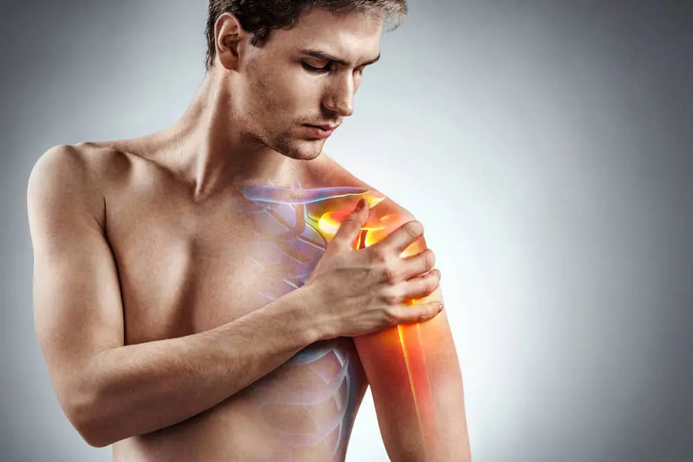 Man with shoulder pain holds left arm