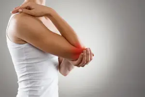 woman holding her elbow due to arthritis pain