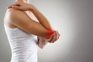 Side view of a woman holding her elbow with pain