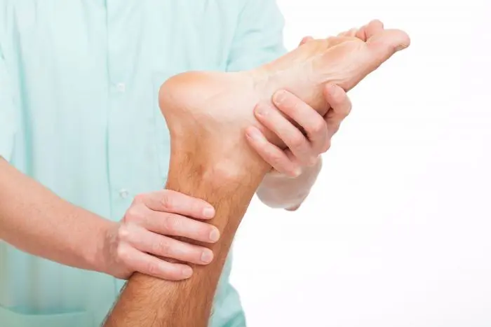Chiropractor treating a patient's foot due to pain from plantar fasciitis.