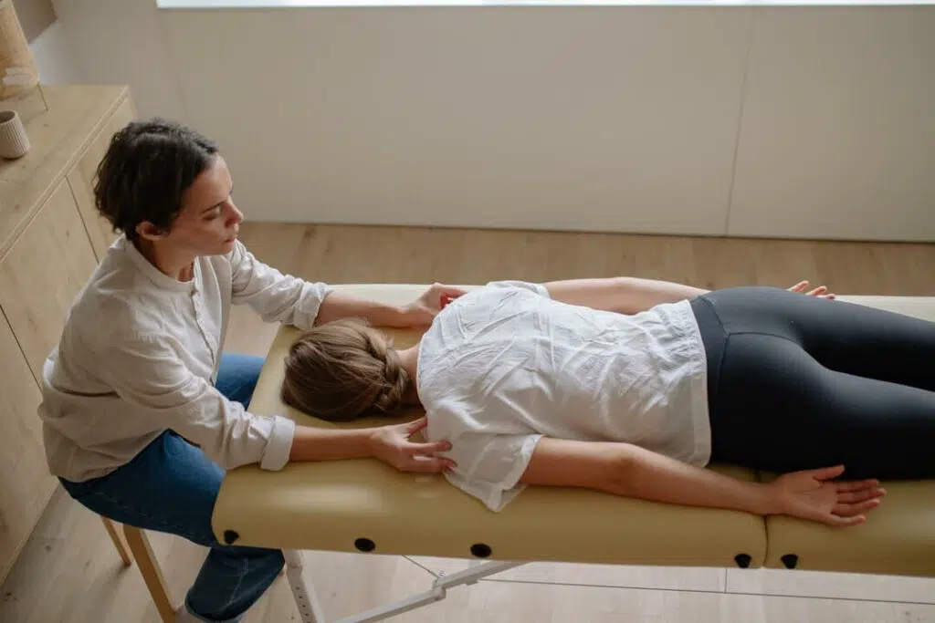 Physical therapist doing the spinal decompression to the patient on a chiropractic table.