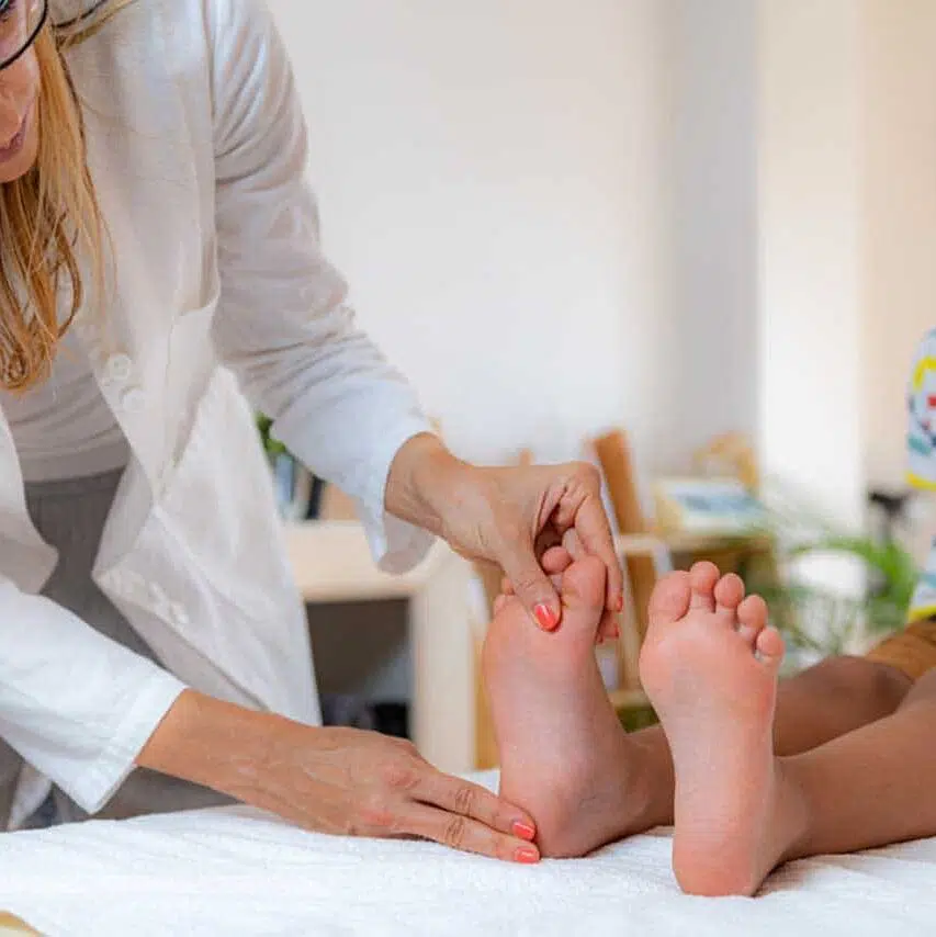 pediatric chiropractic in sugar land examining development boys feet on a bed.