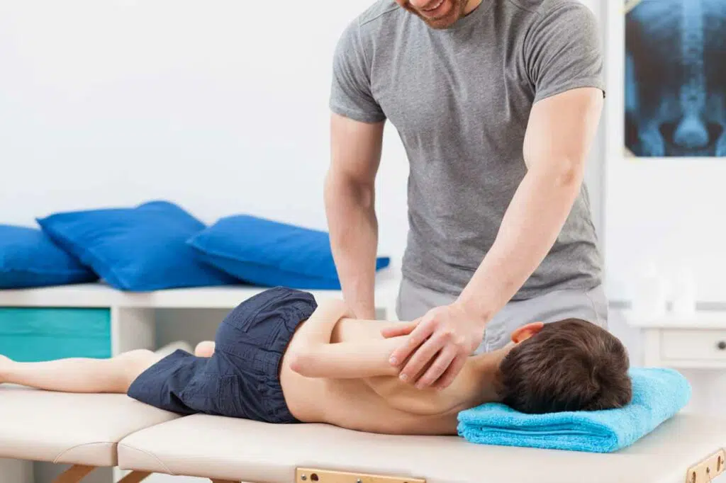 Young boy on a drop table getting adjustments from a pediatric chiropractor