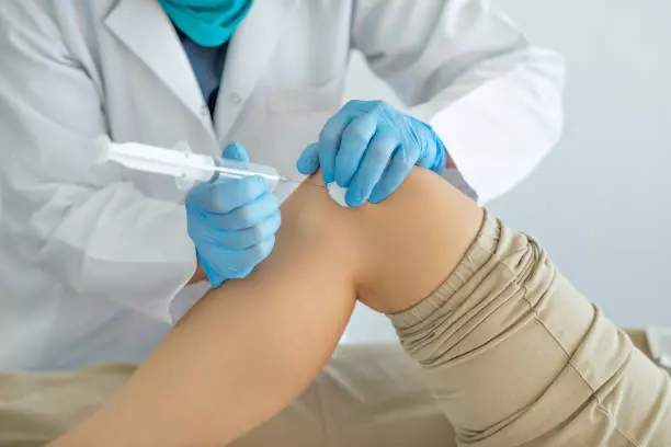 Doctor injecting HCT/P Stem cell to the patient's knee joint