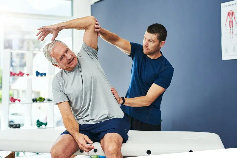 chiropractor assessing male patient through his insured and covered chiropractic care