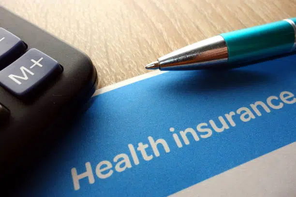 Health insurance form, pen and calculator