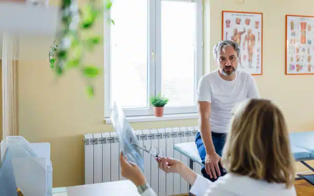 Female doctor explaining spine x-ray to patient in the medical office.