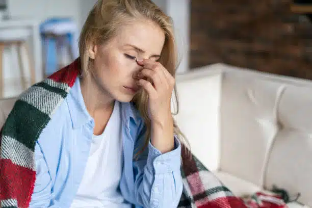 Fatigue and upset woman touching nose bridge feeling eye strain or headache.