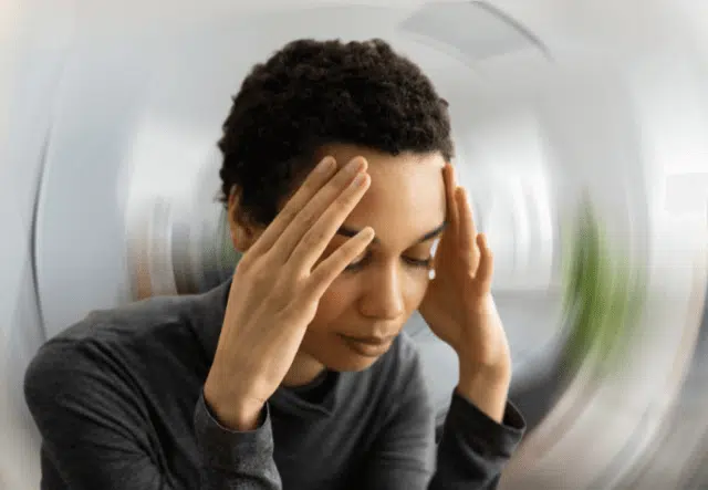 Woman holding her head feeling of too much pain caused by vertigo.