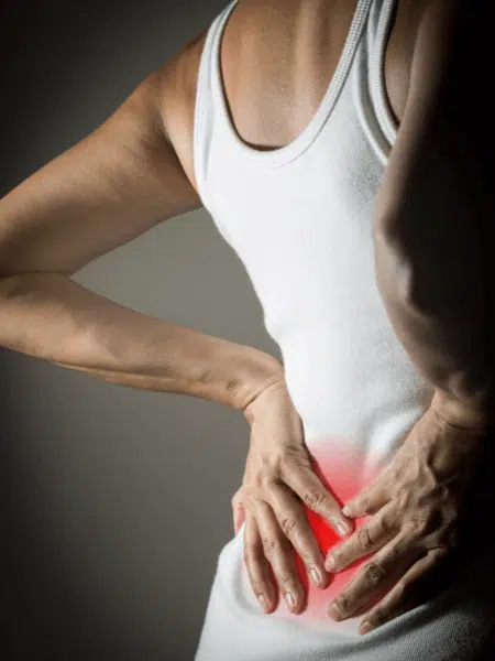 woman holding her back feeling of intense pain caused by backpain and arthritis.