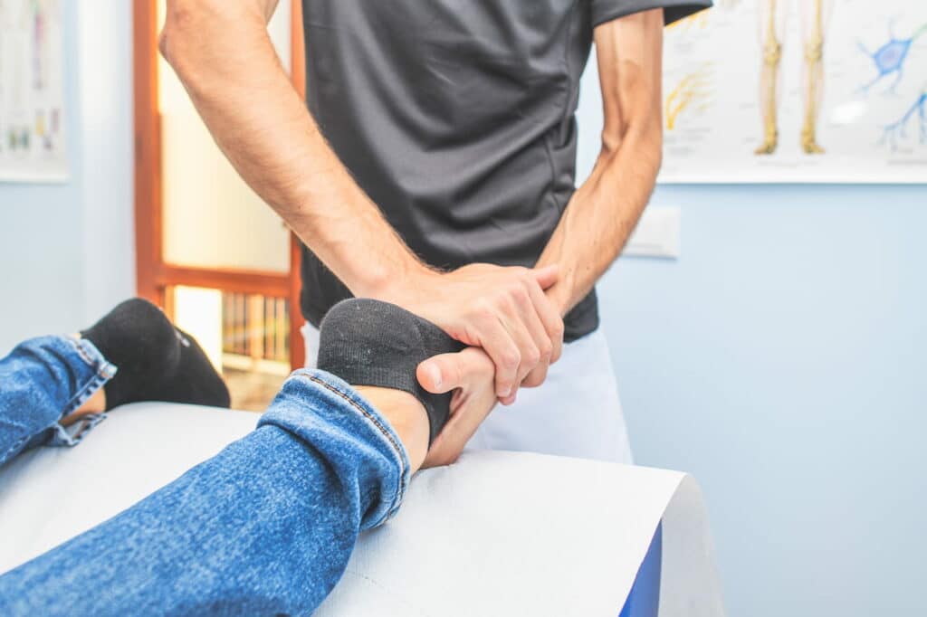 Physiotherapist doing some treatment to the patients ankle