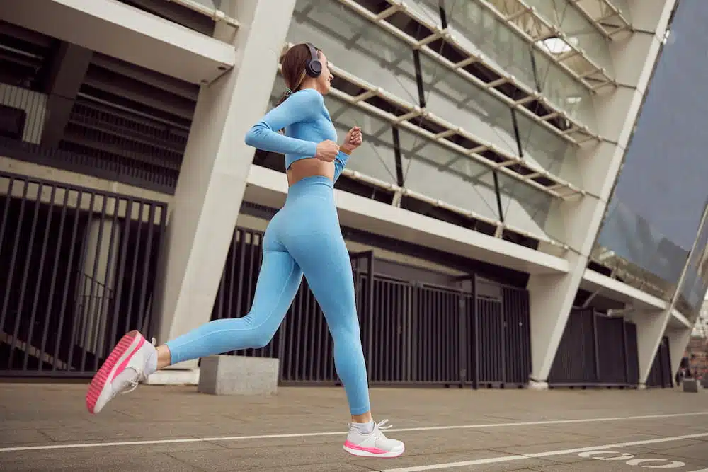 Woman running outside, doing some outdoor exercise.