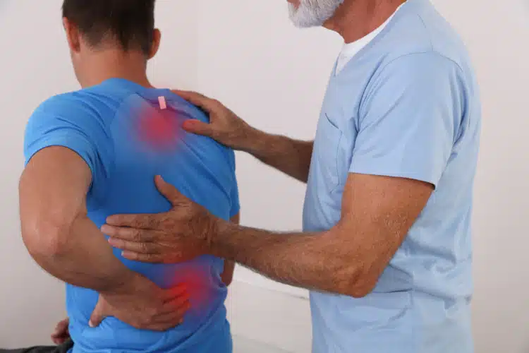 Chiropractor doing back adjustment to the patient.