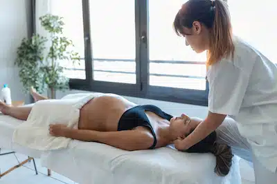 pregnant getting neck massage from an expert chiropractors at a clinic