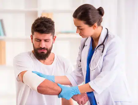 therapist applying bandage on injured man