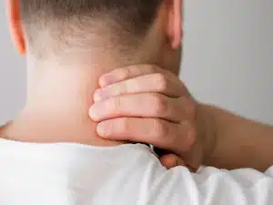 man with text neck holding his neck from pain