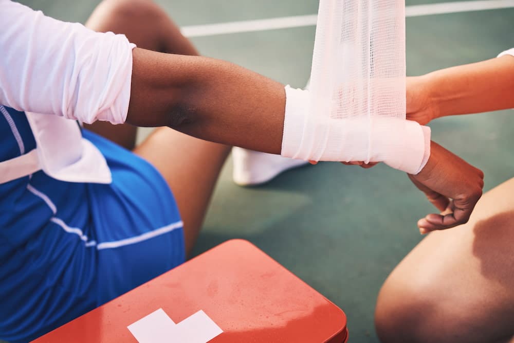 man with wrist injury getting first aid treatment 